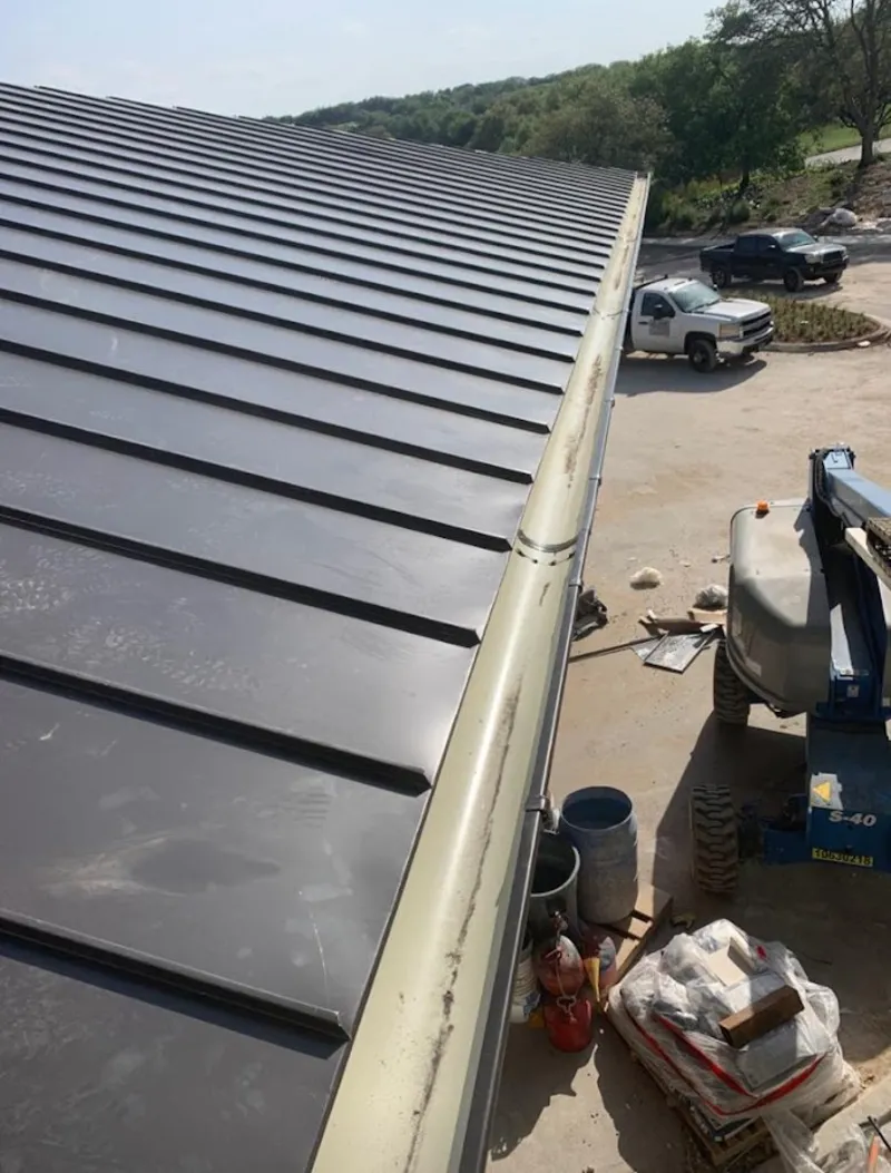 Standing seam panel and gutter detail on a metal roofing jobsite in Lake of the Pines